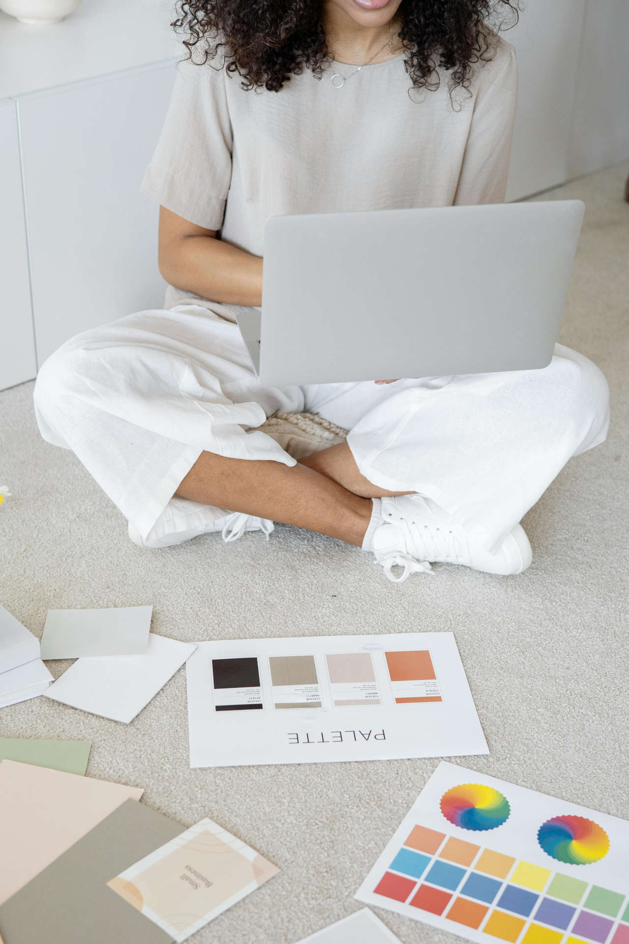 Woman sitting with laptop and swatches