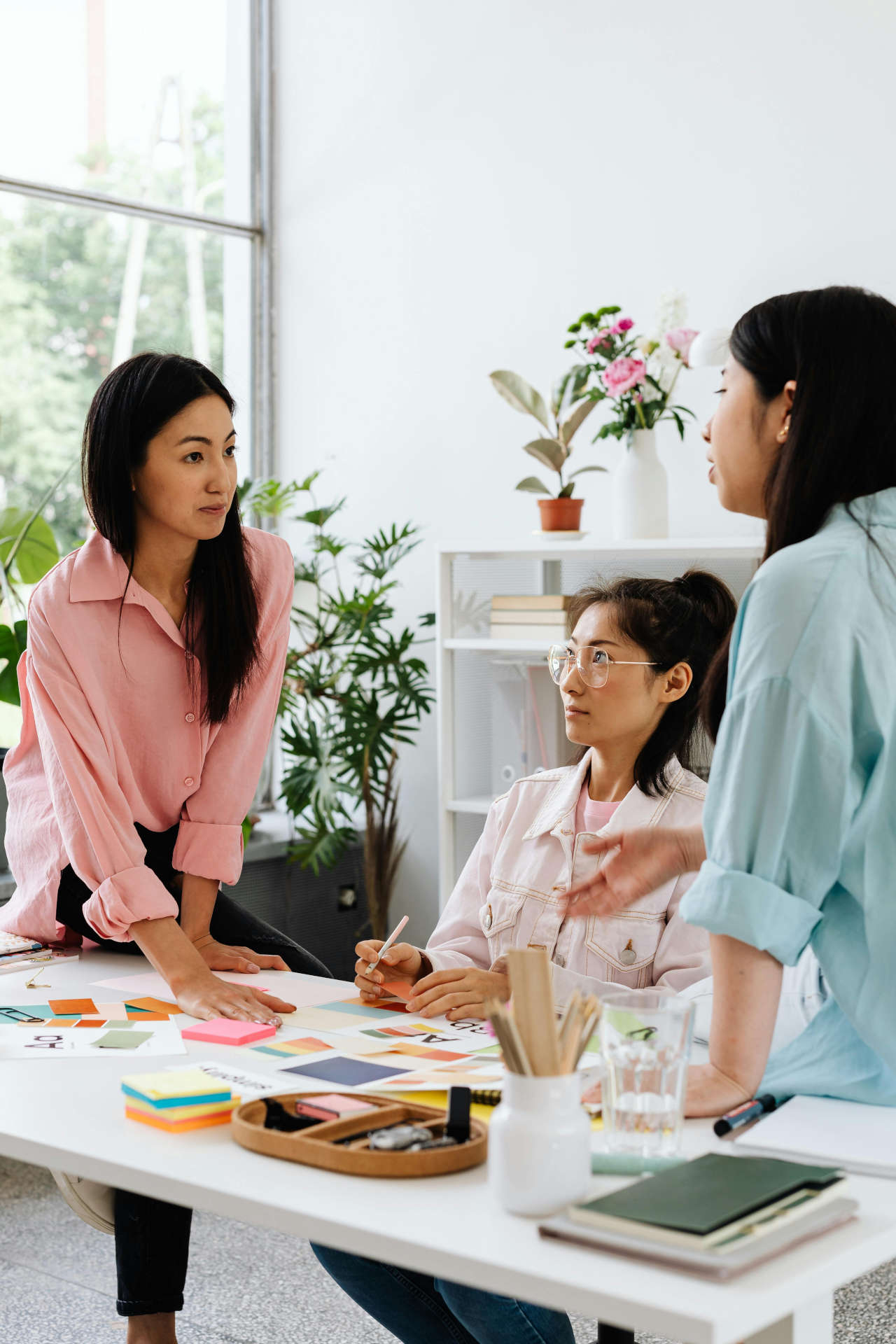 Three Women Talking at a Desk