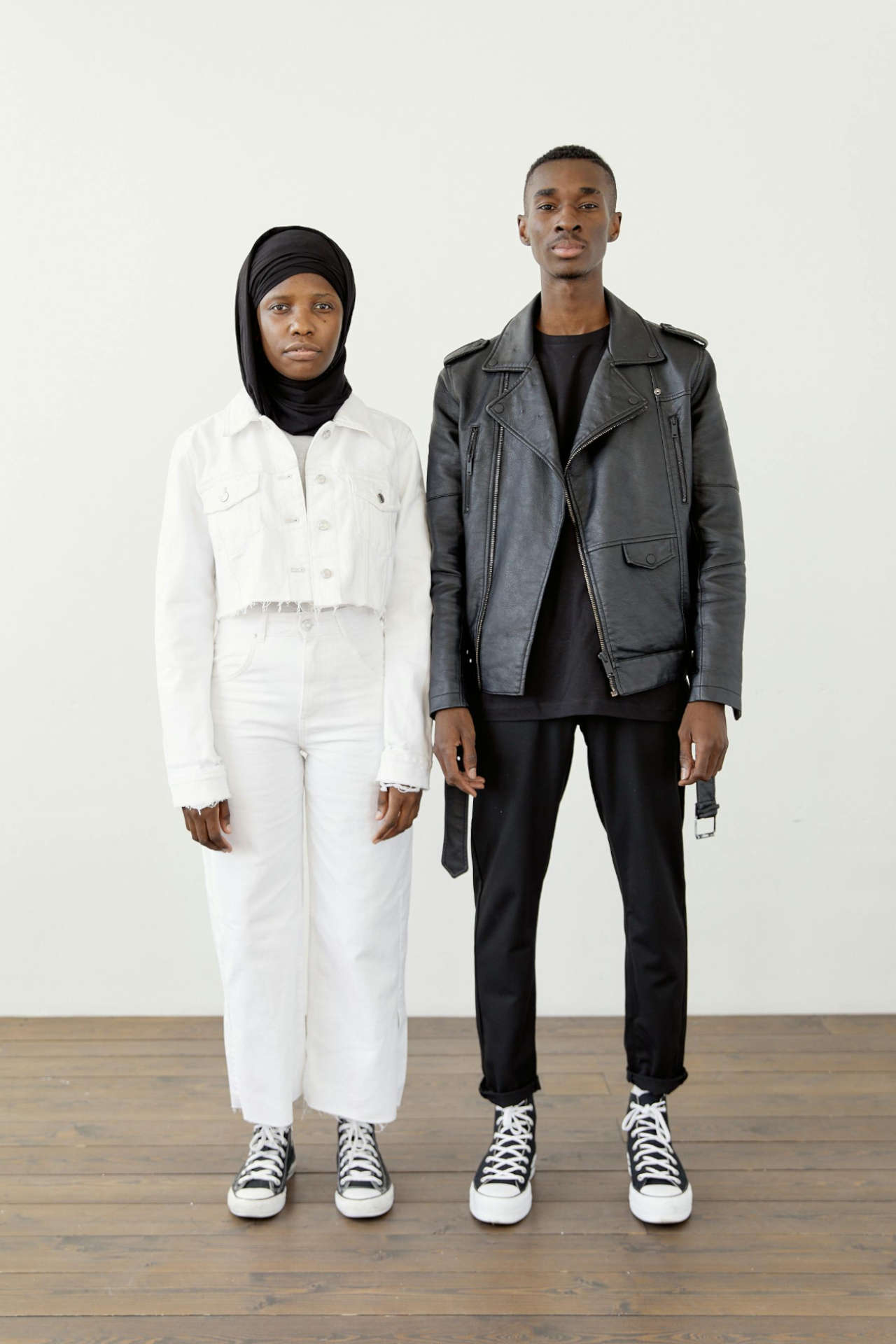 Two People Standing Against a White Background