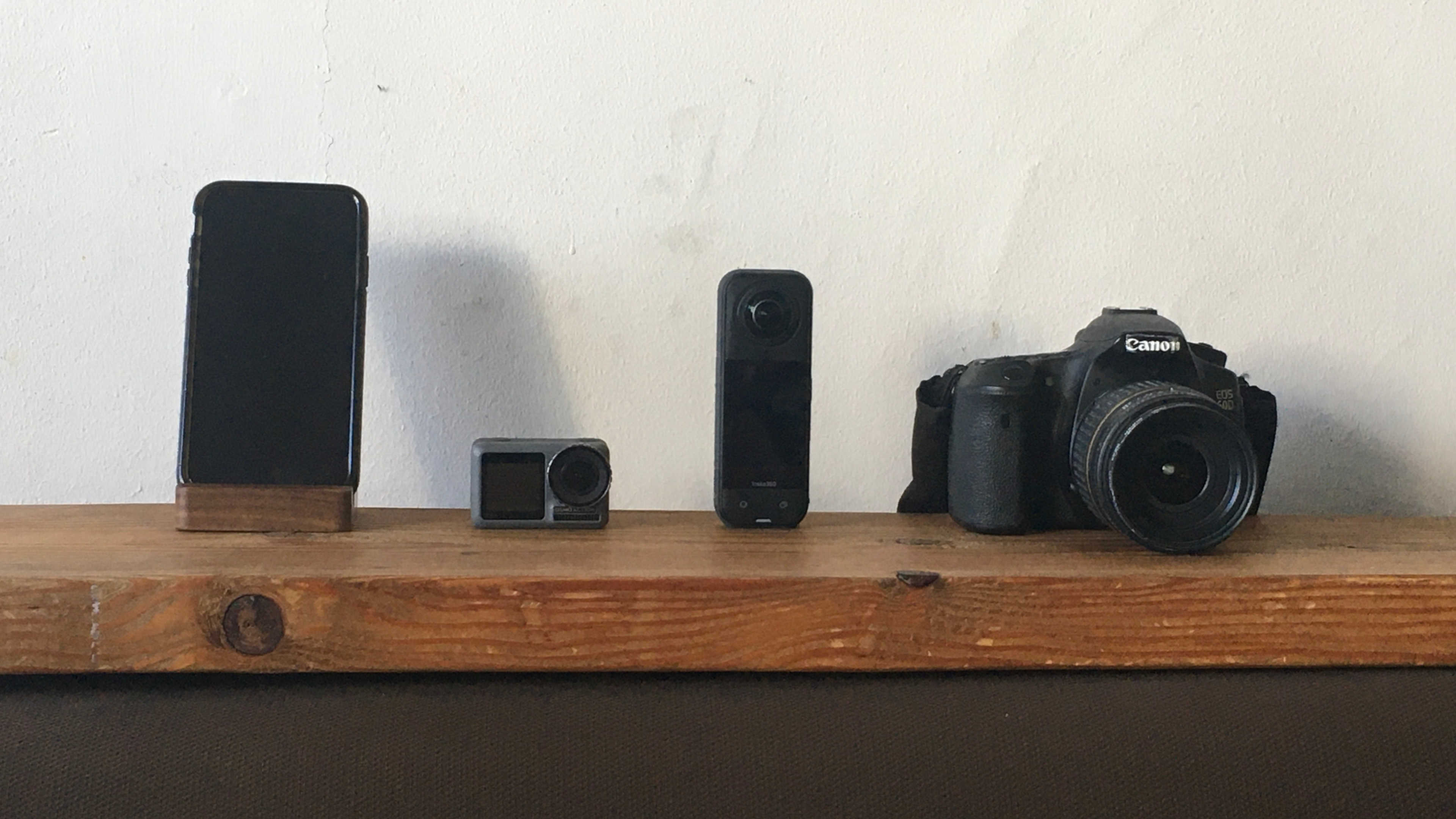Assortment of camera gear including smartphone, action camera, DSLR and 360 camera