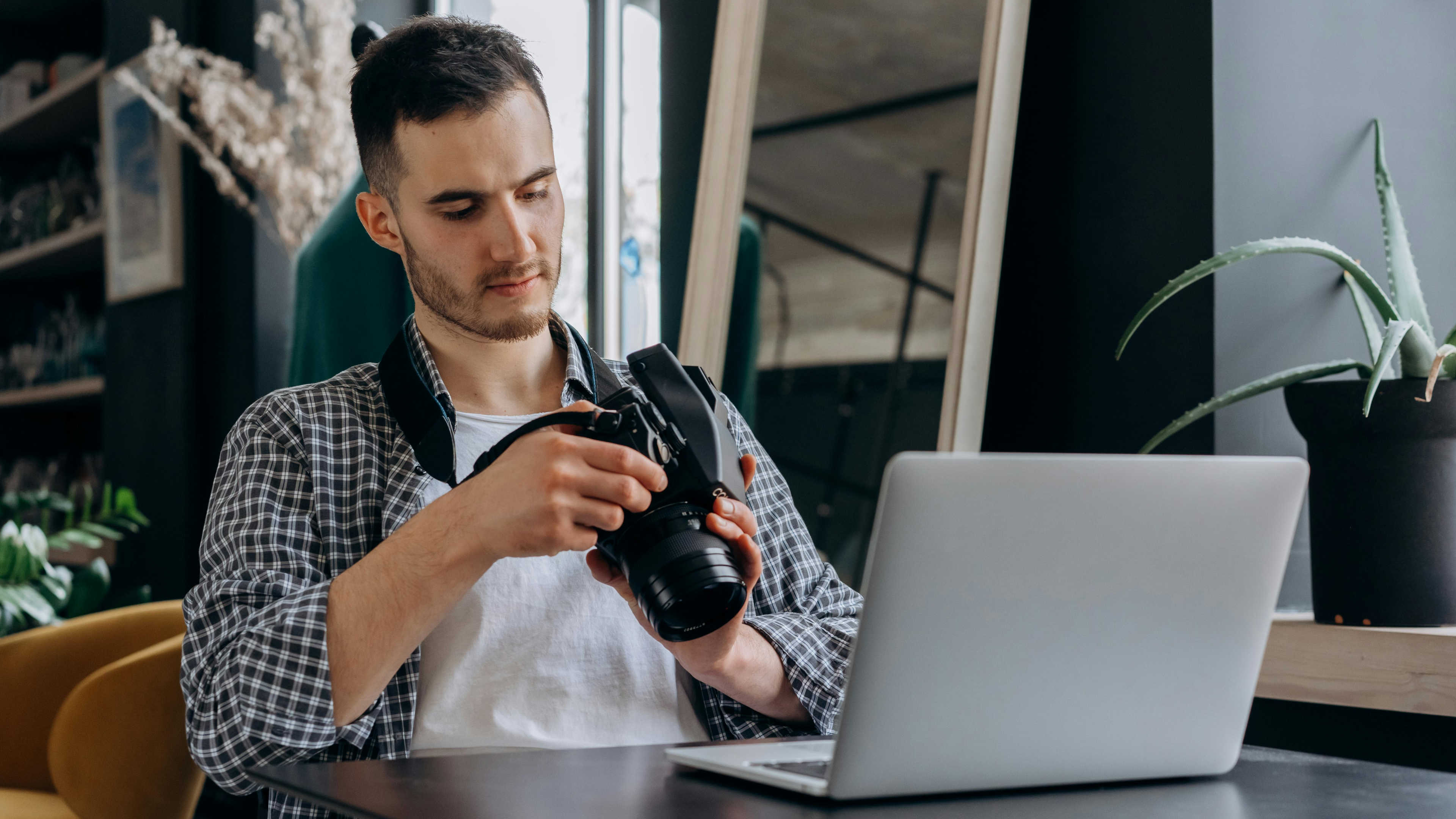 A person reviewing their footage on a laptop after a trip, surrounded by gear.