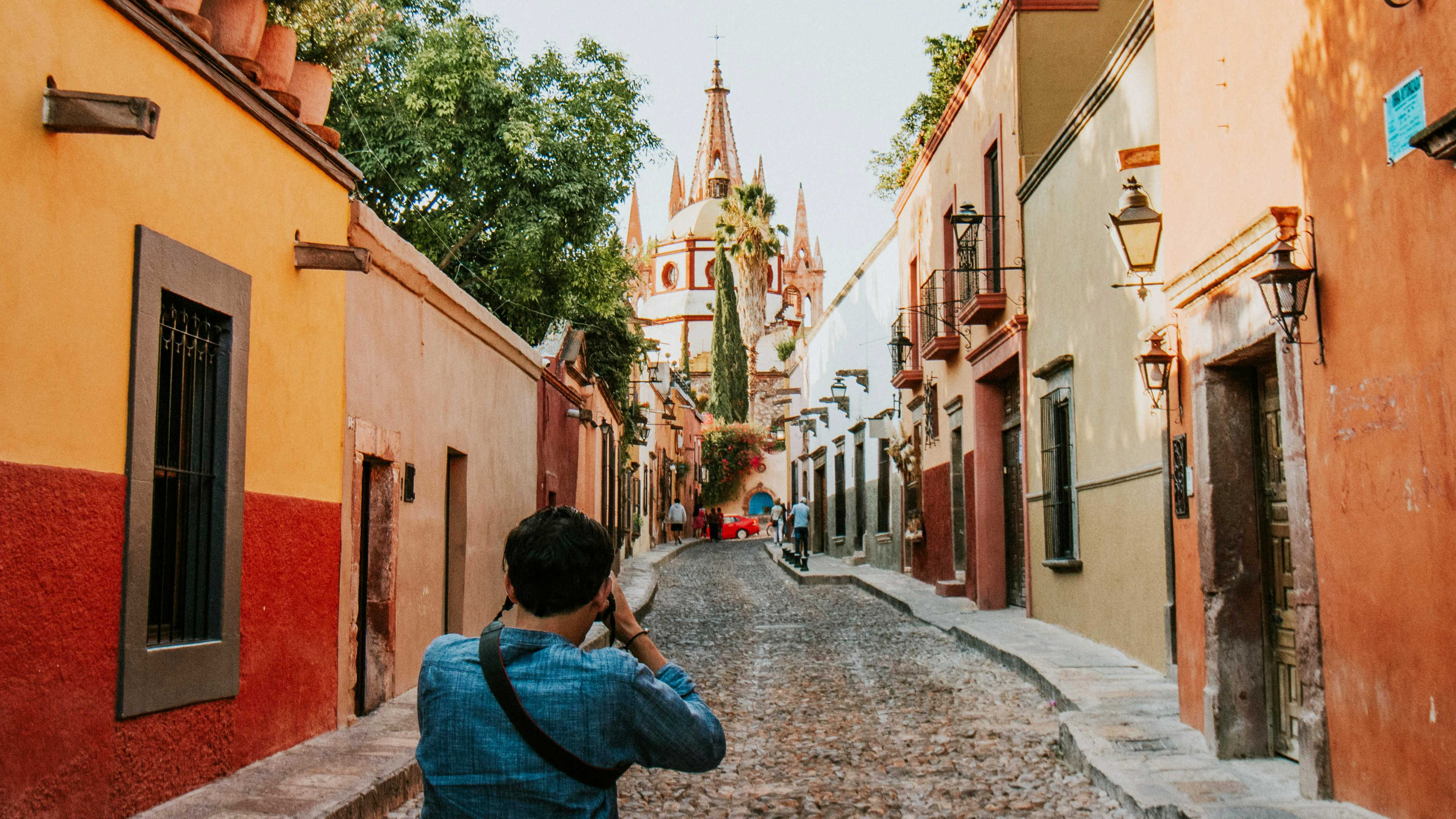 A man taking a photograph in a colorful street