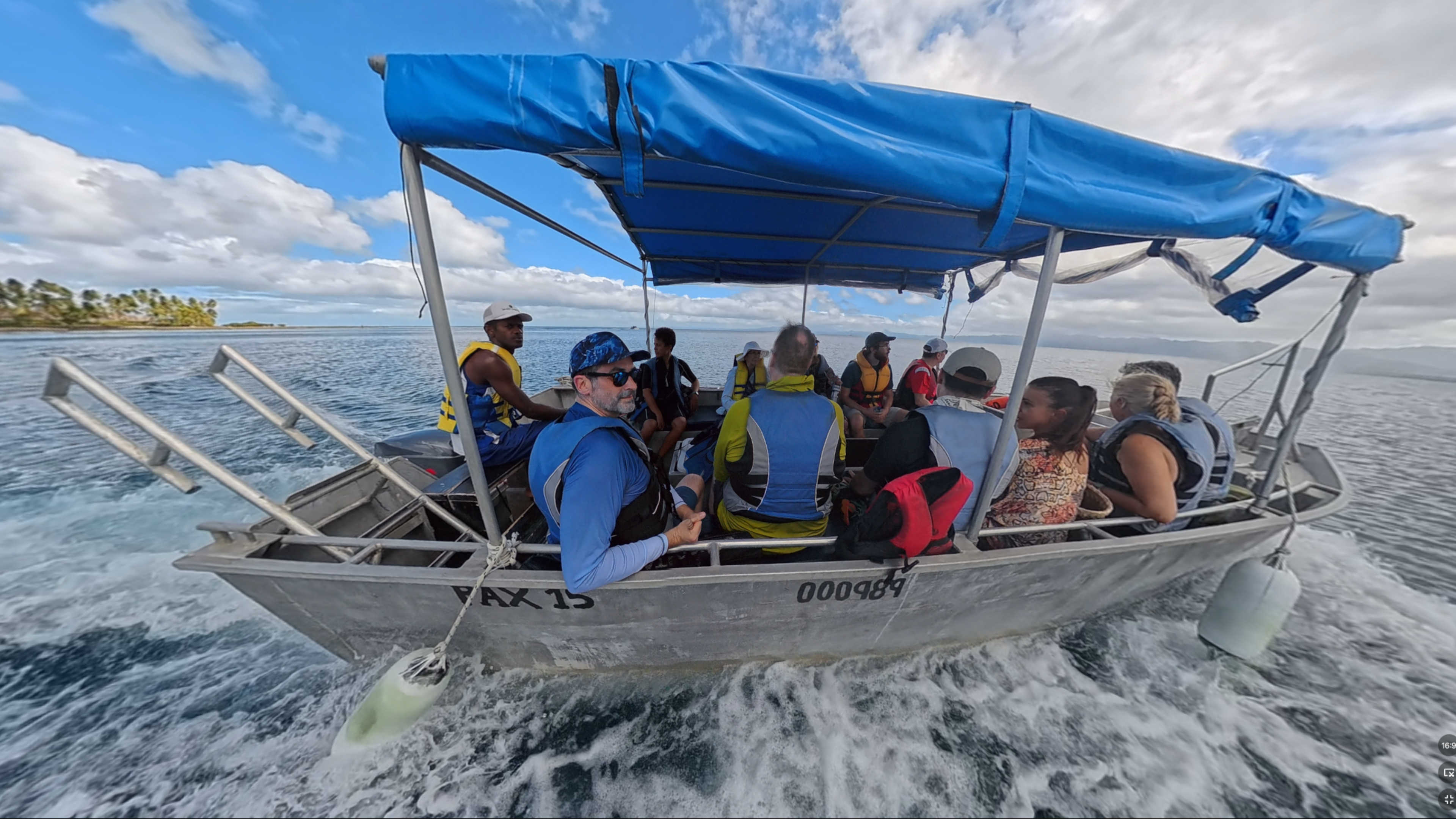 Our boat with myself, my family and several passengers wearing life jackets heading out to sea