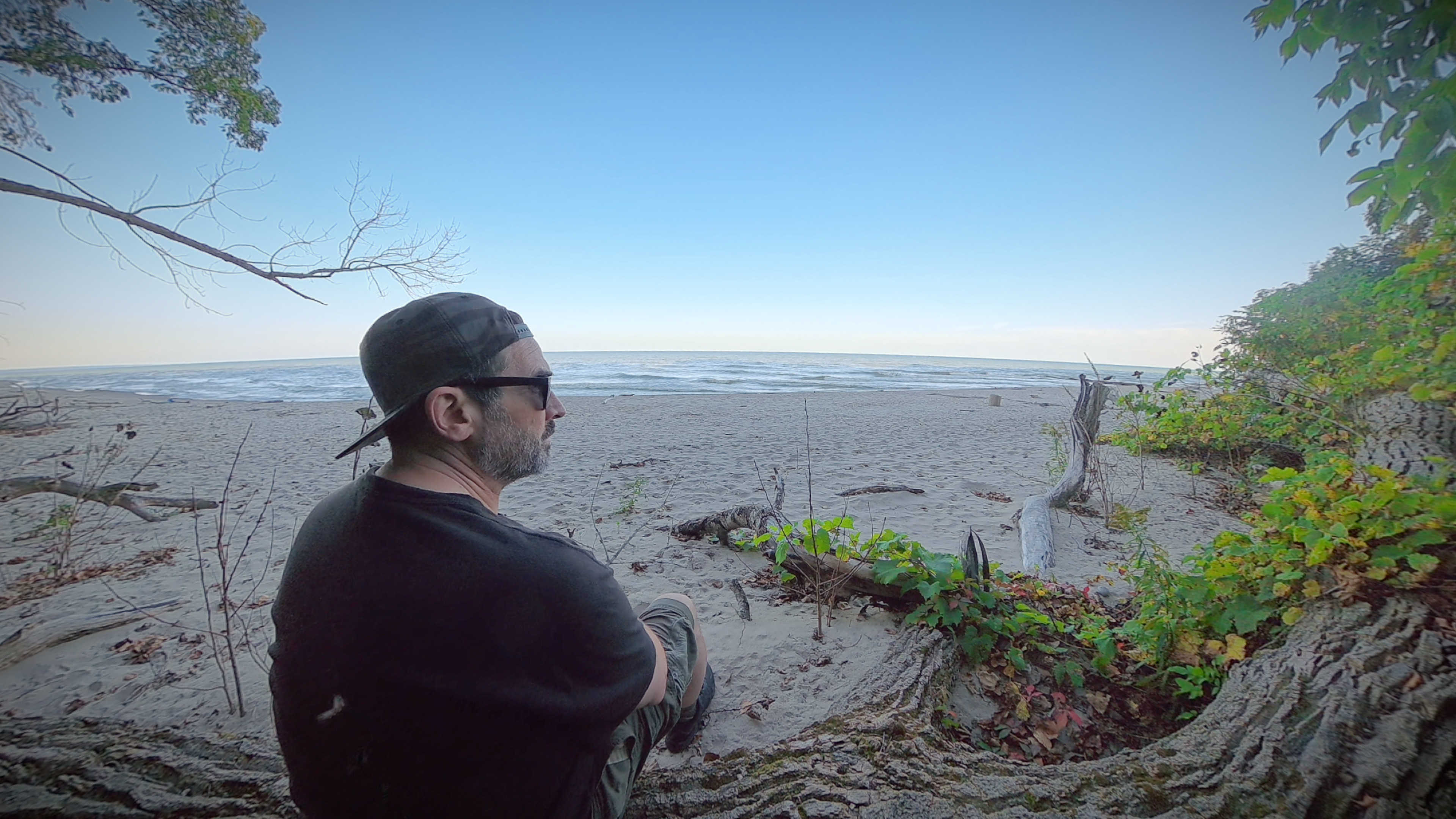 Me sitting on a log on the beach by the lake