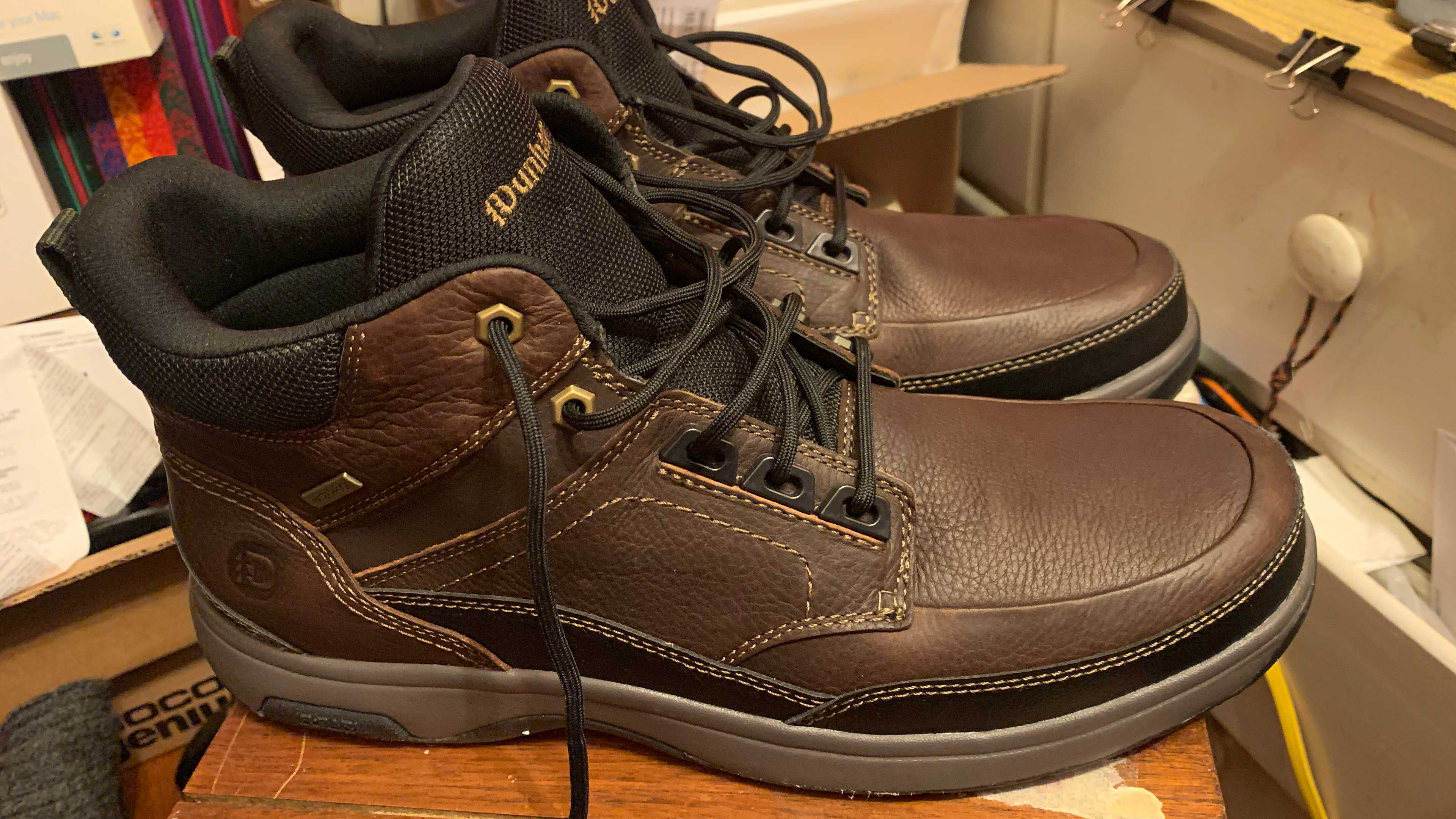 Brown leather, waterproof Dunham boots on a chair in a bedroom