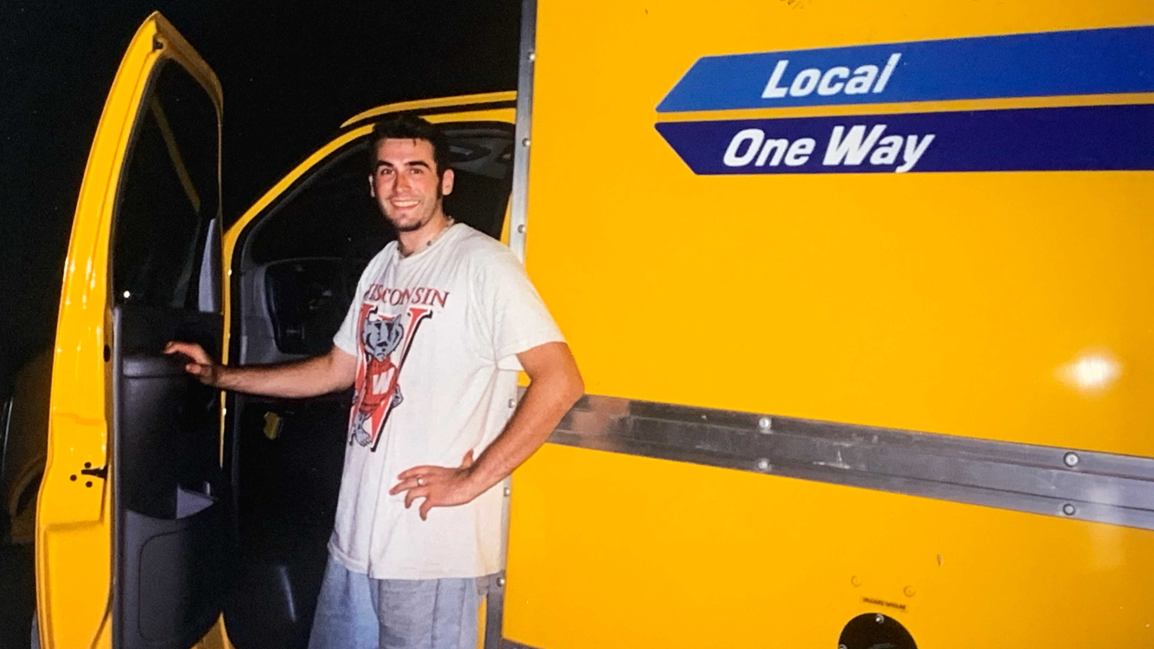 Me as a young man standing by a yellow moving truck